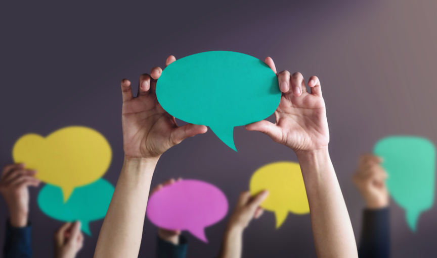 Illustrating the concept of citizen engagement, multiple pairs of hands each holding up a paper speech bubble